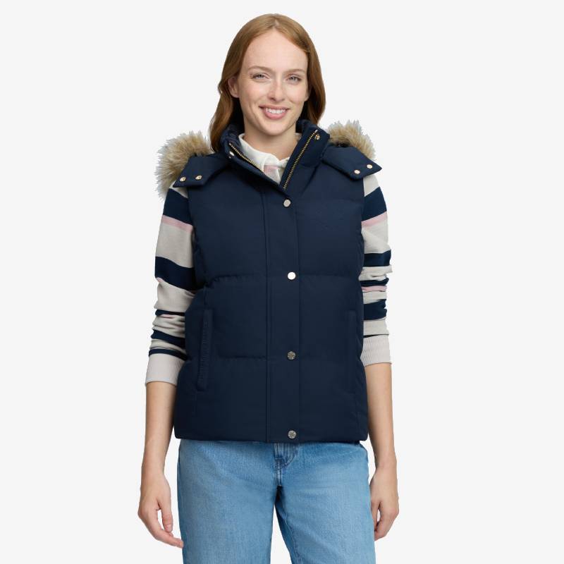 Woman wears LeMieux Margot Hooded Gilet Navy, striped sweater, jeans, and smiles at the camera.