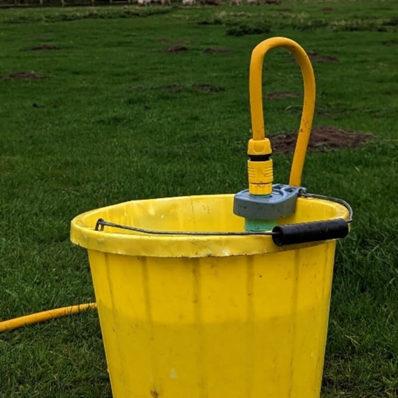 SealStop Valve by SealStop on grass with packaging, garden background softly blurred.