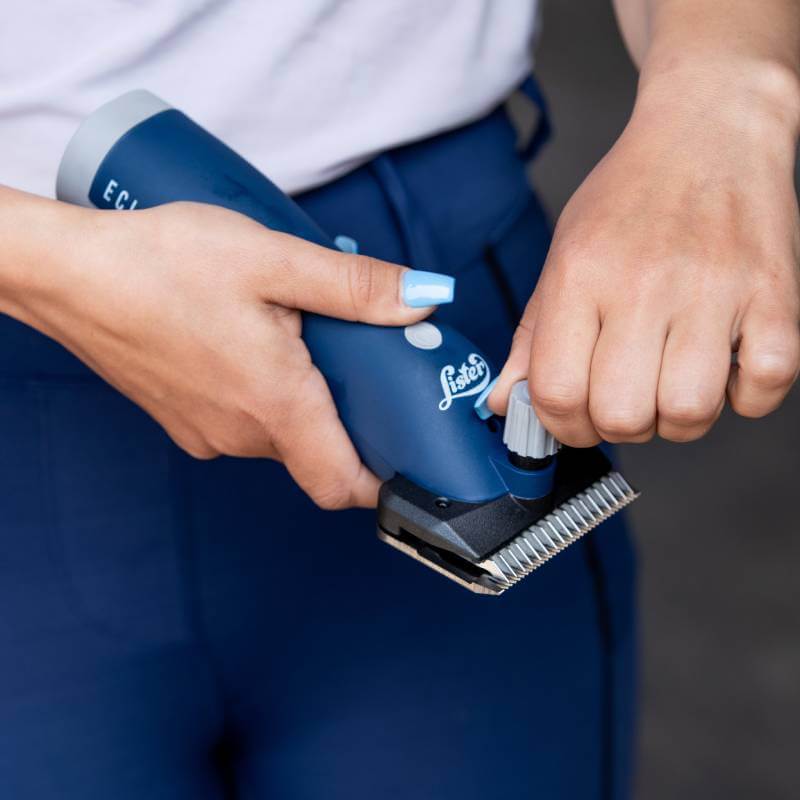 Person adjusting the Lister Eclipse 2.0 Clippers Promo Kit with silver blades.