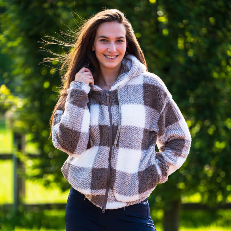 Woman smiles outdoors in a Mountain Horse Chess Fuzzy Fleece White jacket.