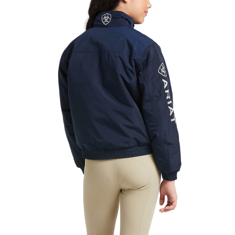 Girl in an Ariat Youth Stable Jacket Navy and beige pants, turned slightly to the side.