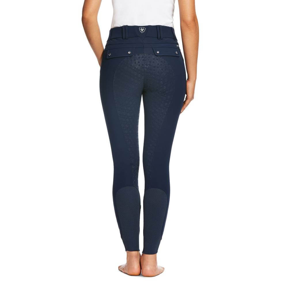 Woman stands barefoot in Ariat Tri Factor Grip Full Seat Navy, shown from the back on white.