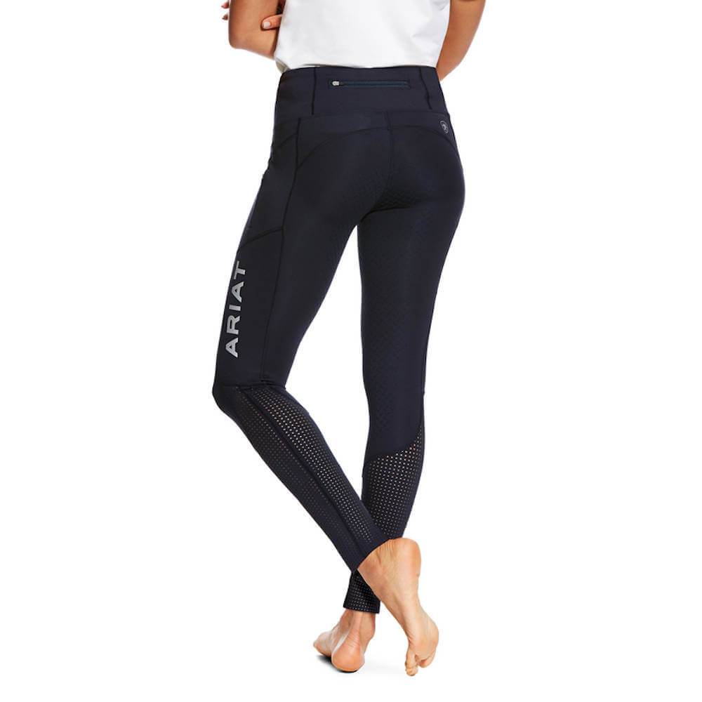 Woman in Ariat Womens Eos Full Seat Tights and white top, barefoot with hand in pocket.