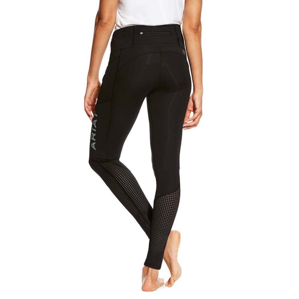 Wearing Ariat Womens Eos Knee Patch Tights in black with a white top, standing barefoot.