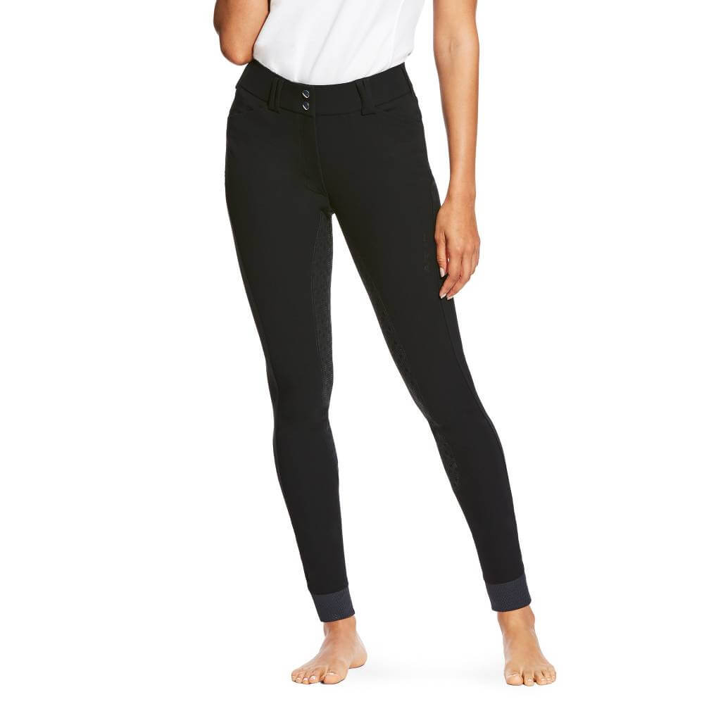 A person in Ariat Tri Factor Grip Full Seat Black pants and a white shirt stands barefoot.