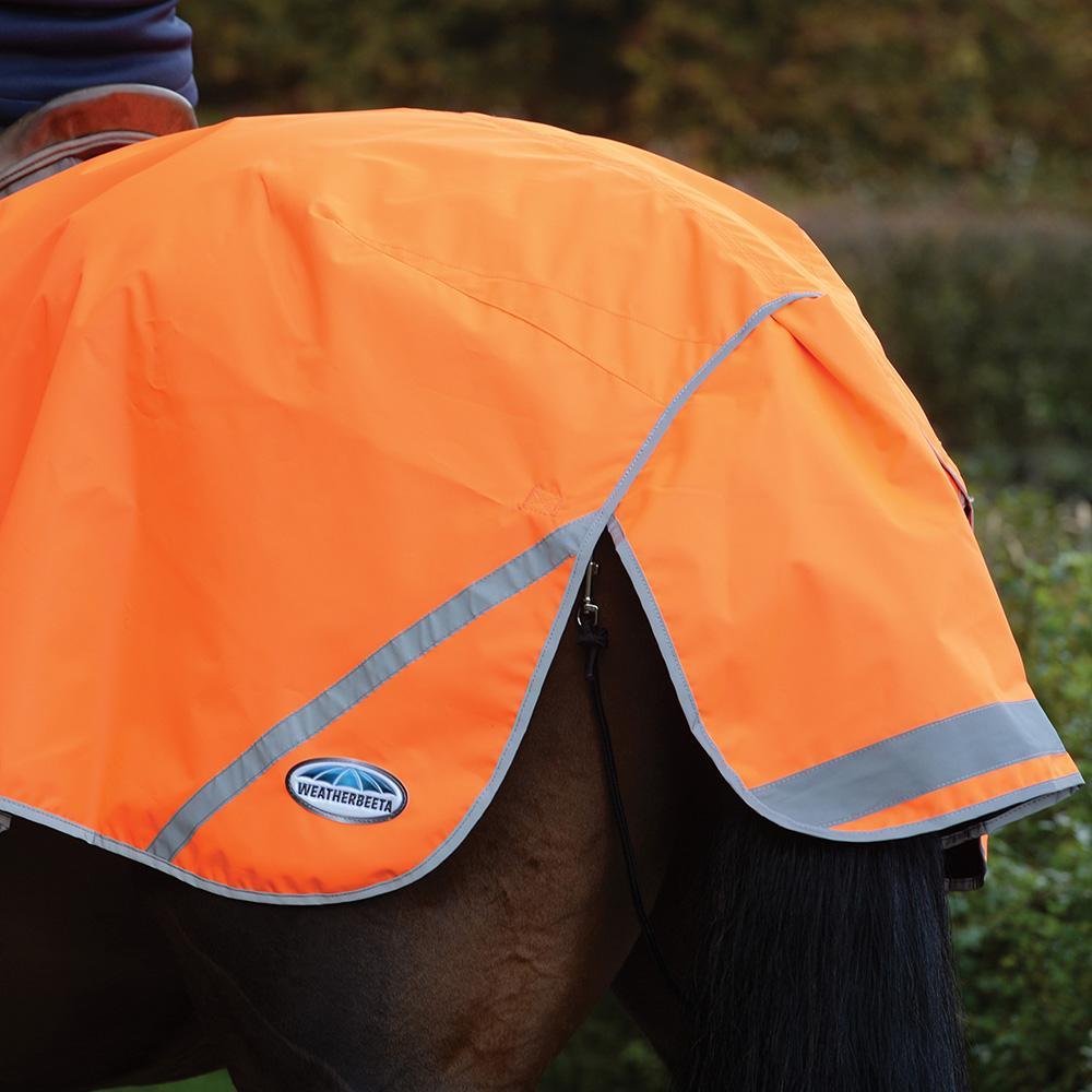A horse sports a Weatherbeeta 300D Reflective Exercise Sheet, staying dry and visible outdoors.