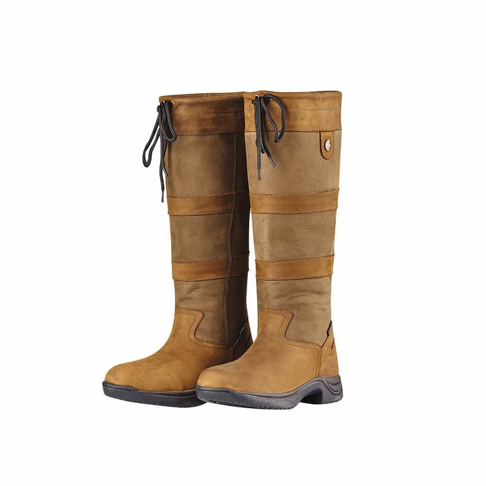 Wearing Dublin River Boots III and jeans, a person stands by a puddle outdoors.