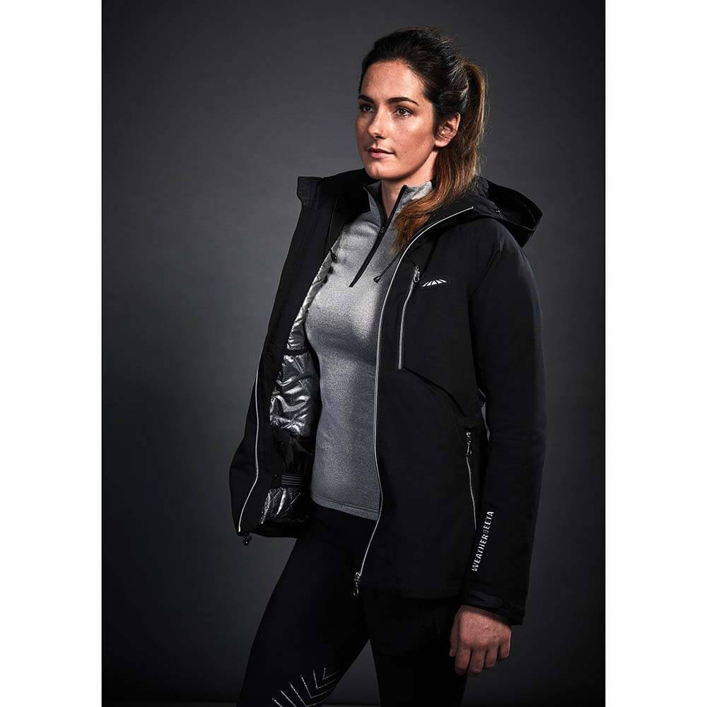 Woman wearing the Weatherbeeta Tania Waterproof Jacket Black by Weatherbeeta against a dark background.