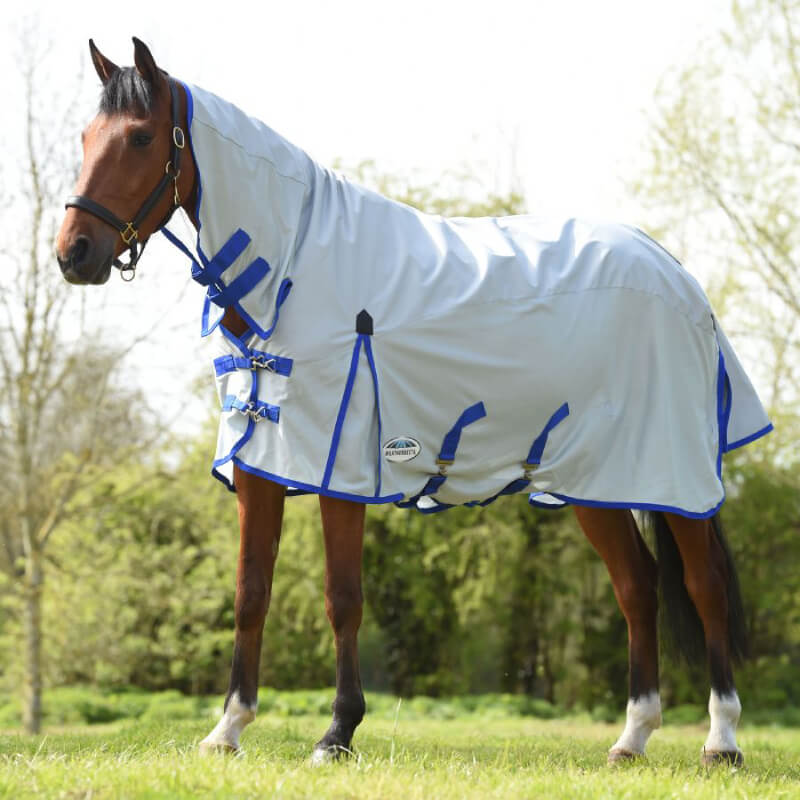 A horse in a Weatherbeeta Comfitec 600D/Mesh II Combo Neck grazes in a grassy field.