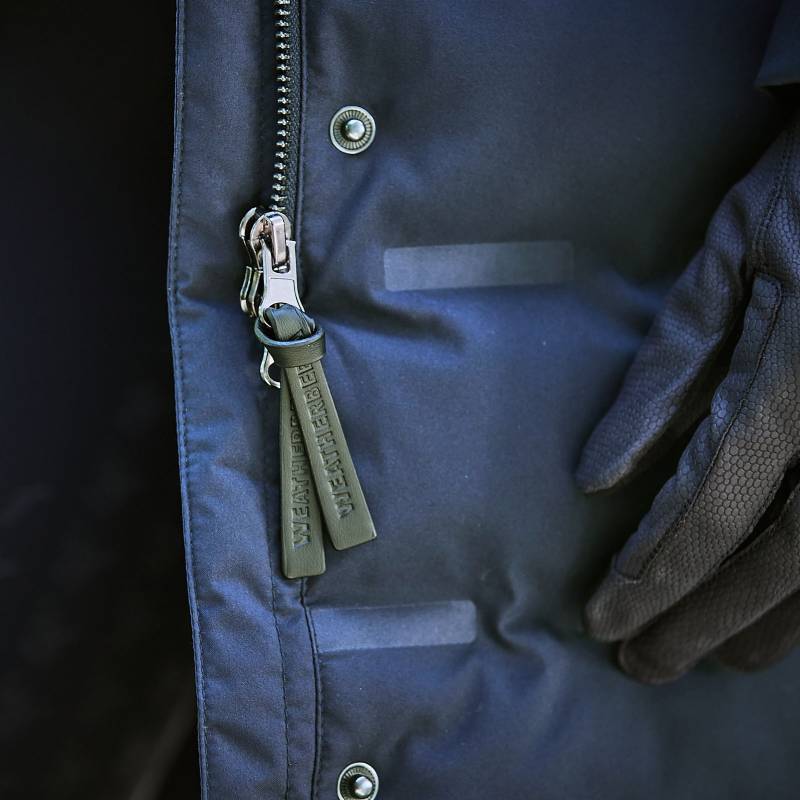 A gloved hand touches the Weatherbeeta Helsinki Heat Seal Quilted Jacket in Navy Iris.