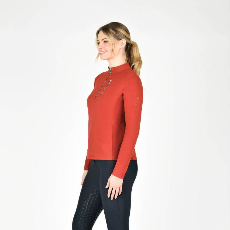 Woman wears Weatherbeeta Reno Long Sleeve Riding Top Red Ochre and black UPF 50+ leggings.