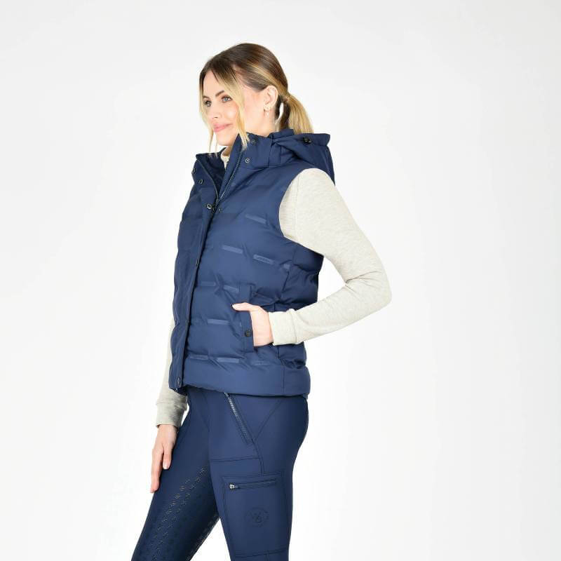 Woman wearing Weatherbeeta Hapur Heat Seal Quilted Vest in Navy Iris stands sideways.