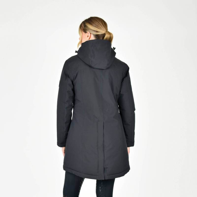 Woman in a Weatherbeeta Kyla II Waterproof Jacket Black stands smiling with hands in pockets.