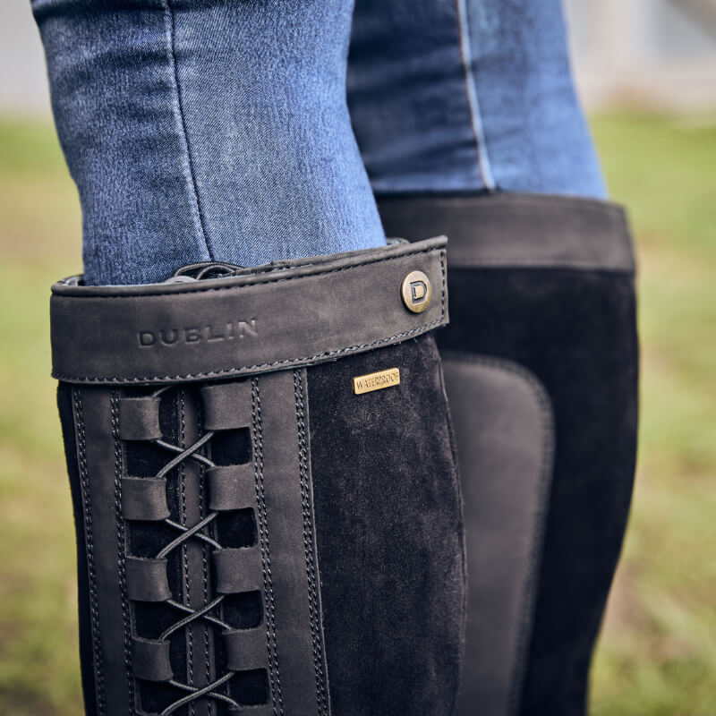 Close-up of Dublin Pinnacle Boots III Black by Dublin, laced and worn over blue jeans outdoors.