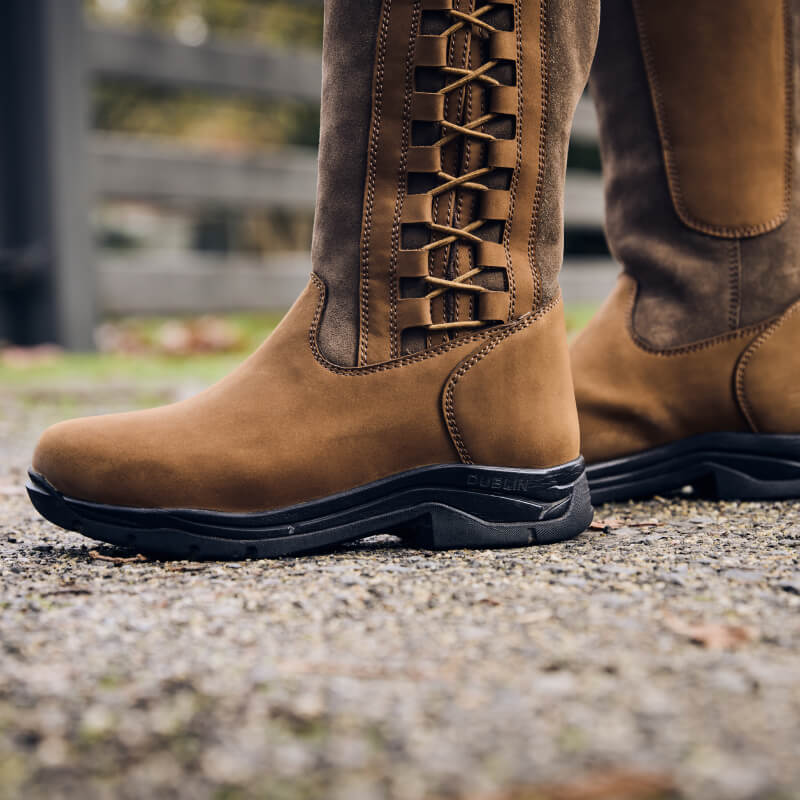 Close-up of Dublin Pinnacle Boots III Dark Brown with side lacing, standing on gravel.