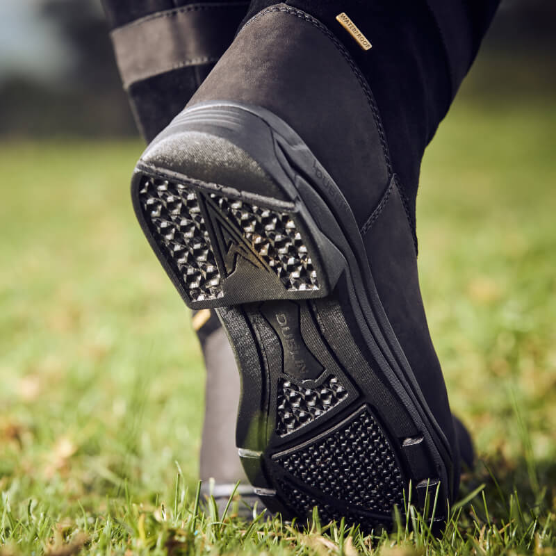 Dublin River Boots IV Black by Dublin shown with textured grip, walking on grass.
