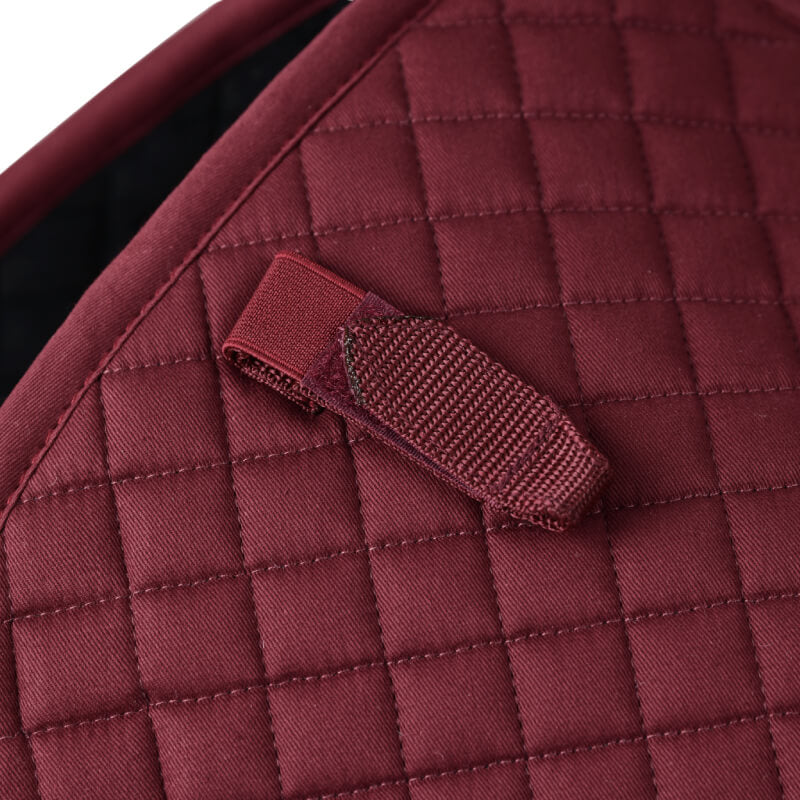 Close-up of a burgundy Weatherbeeta Prime Air-Tec Jump Shaped Saddle Pad with stitched loop.