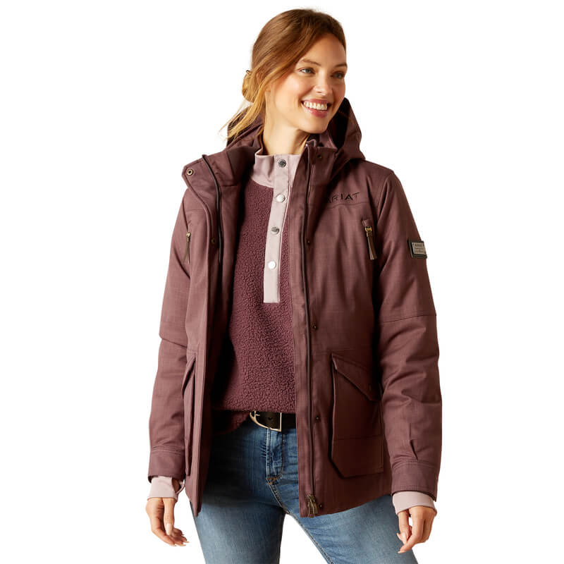 Smiling woman in an Ariat Sterling Insulated H2O Parka Raisin, standing against a white background.