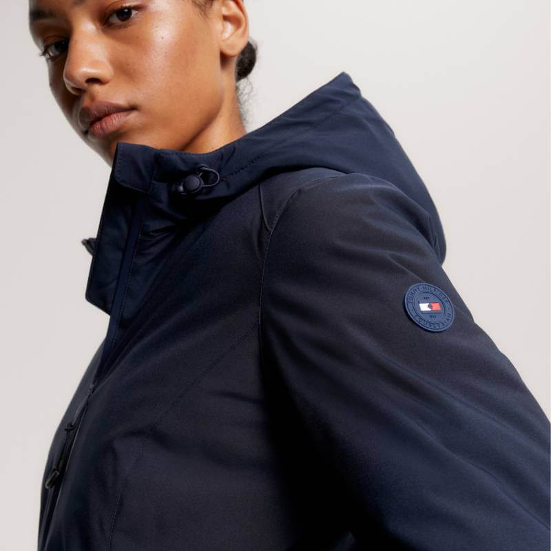 Person wearing a Tommy Hilfiger London Winter Riding Jacket in Desert Sky with sleeve logo patch.