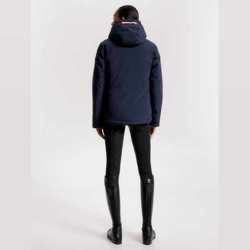 Person in a Tommy Hilfiger London Winter Riding Jacket, black pants, and boots, back to camera.