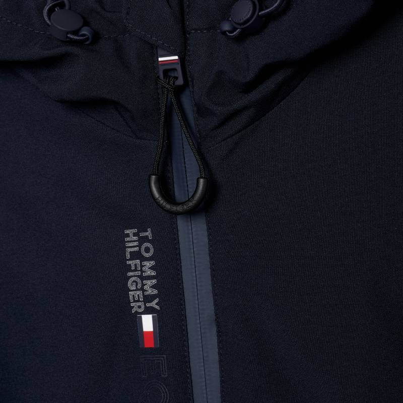 Close-up of Tommy Hilfiger London Winter Riding Jacket Desert Sky showing logo by zipper and hood.