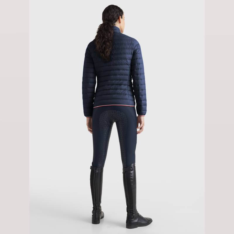 Woman in Tommy Hilfiger Light Re-Down Jacket Desert Sky, riding boots, and dark pants from behind.