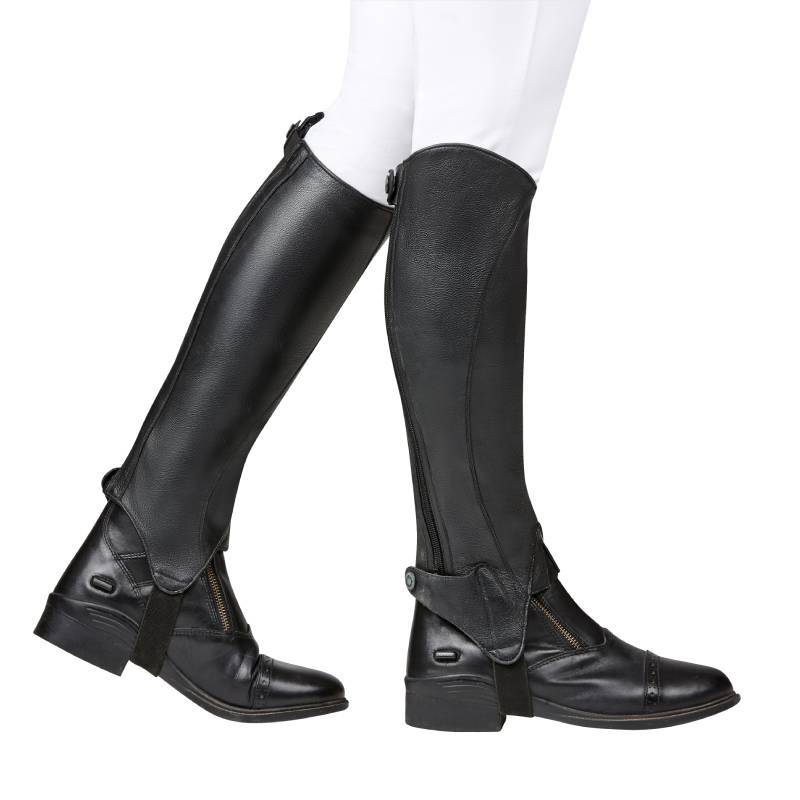 Person in Dublin Opulent Half Chaps Black Adult by Dublin, worn with white pants, side view.
