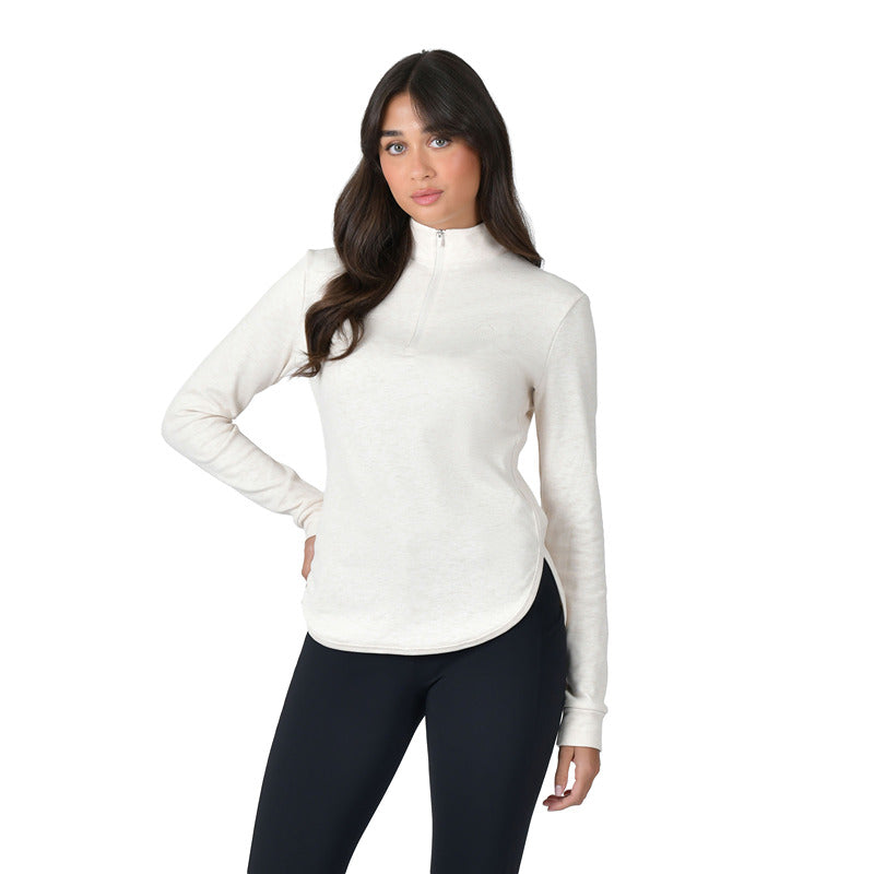 Woman wears Weatherbeeta London Layer Top in light cream marle with black leggings, hand on hip.