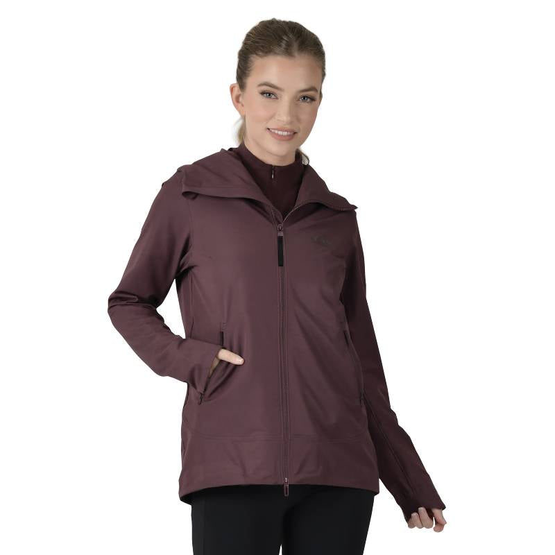 Woman wears Weatherbeeta Abrasion Proof Stretch Riding Jacket Mulberry, smiling at the camera.