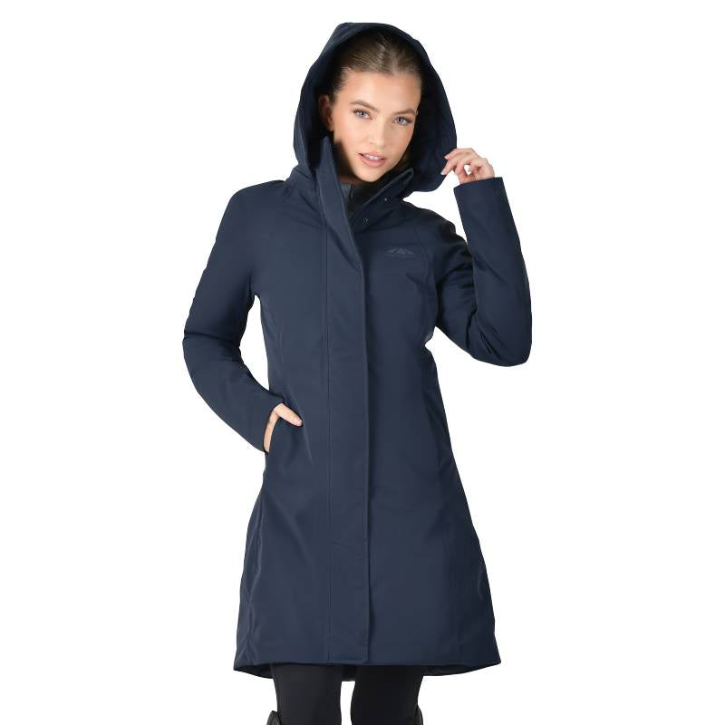 Woman in Weatherbeeta All Purpose Waterproof Longline Equestrian Jacket, hand in pocket, holding hood.