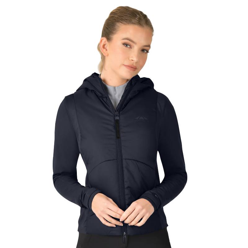 Woman in a Weatherbeeta Hybrid Padded Jacket Navy stands with hands clasped in front.