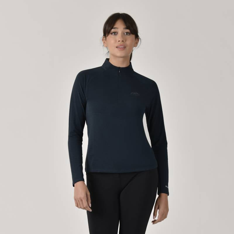 Woman wears a Weatherbeeta Bamboo LS Base Layer Navy and black pants on light background.