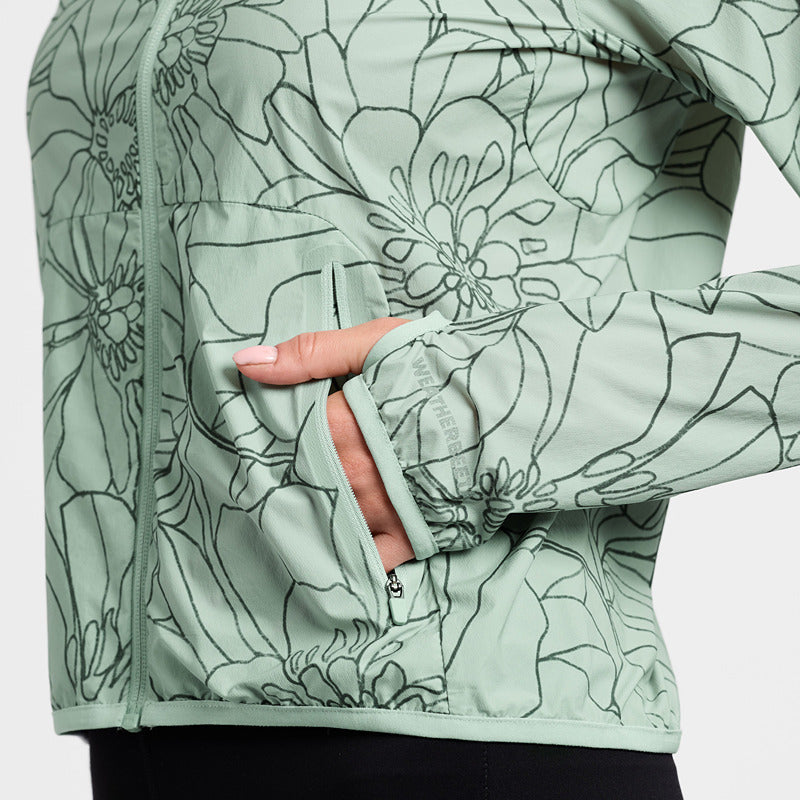 Person wearing a Weatherbeeta Lightweight UV Jacket in Soft Sage/In Bloom with thumbholes and pocket.