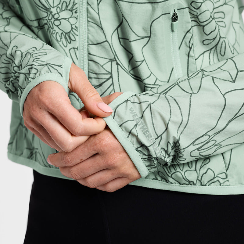 Close-up of hands adjusting the Weatherbeeta Lightweight UV Jacket in Soft Sage/In Bloom floral.
