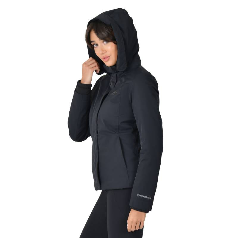 Woman in a Weatherbeeta Protect Jacket With High Neck Black and black pants, facing camera.