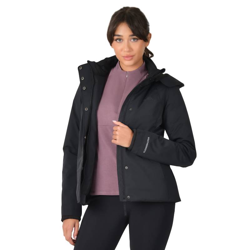 Woman in a Weatherbeeta Protect Jacket With High Neck Black stands, looking at the camera.