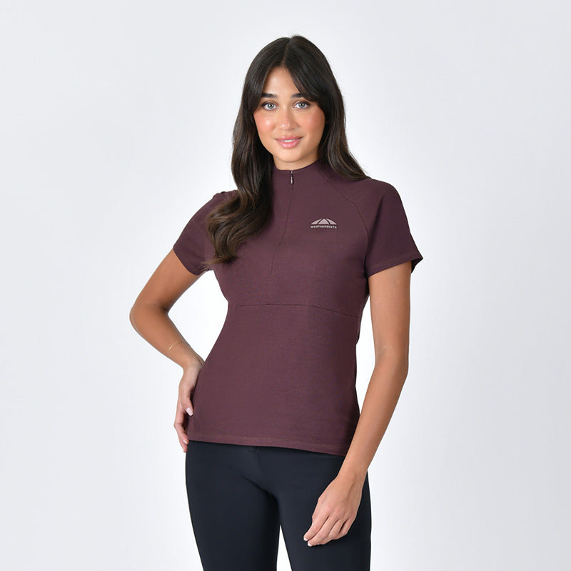 Woman wears a Weatherbeeta Bamboo Short Sleeve Base Layer Mulberry and black pants on a white background.