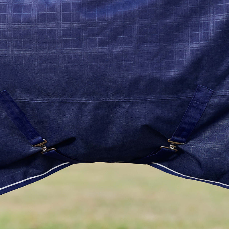 Close-up of Weatherbeeta navy plaid turnout rug with two bottom edge straps.