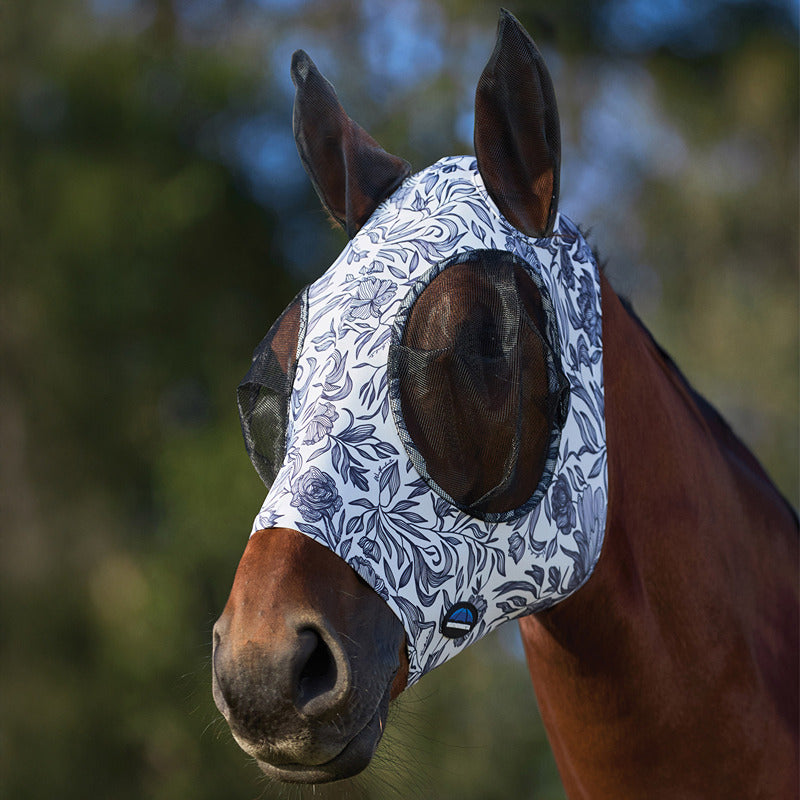 A horse wears a Weatherbeeta floral fly mask with ears for UV protection outdoors.