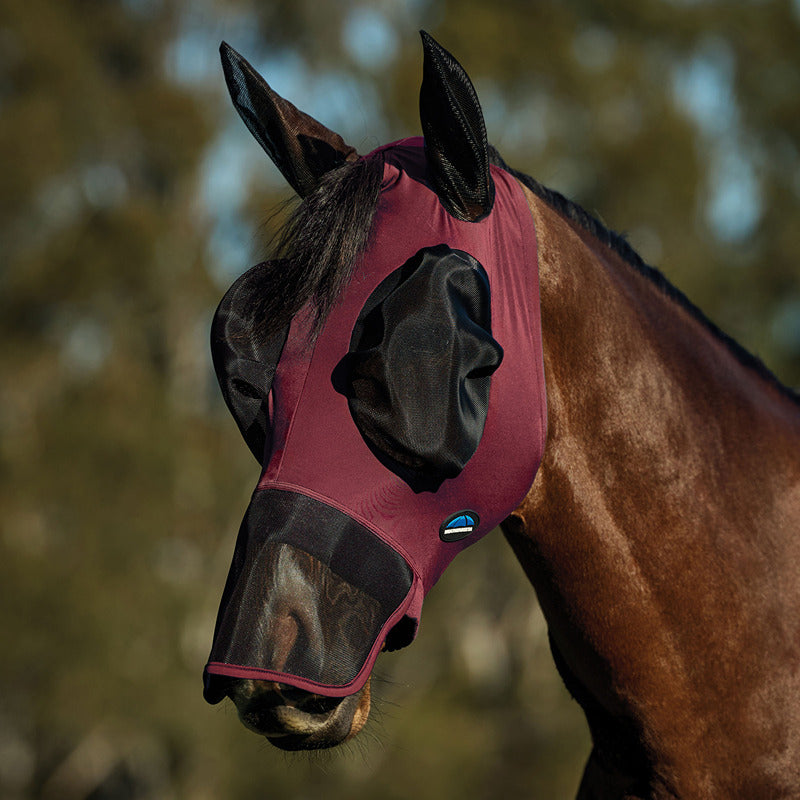 A horse wears a Weatherbeeta Comfitec Luxe Stretch Fly Mask w/ Ears & Nose in Burgundy/Black.