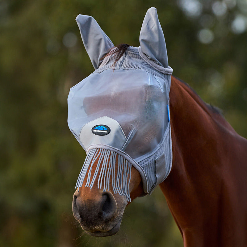 A horse wears a Weatherbeeta Comfitec Fine Mesh Fly Mask With Ears &amp; Tassels in grey.