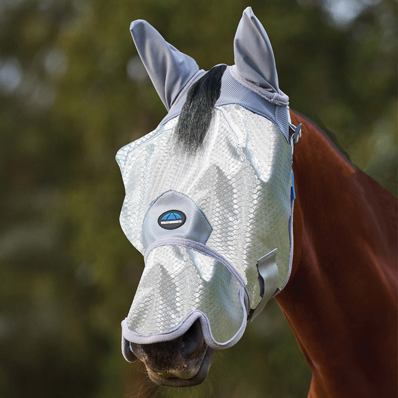 A horse outdoors wears the Weatherbeeta Comfitec Hexi Shield Fly Mask With Ears &amp; Nose Silver.