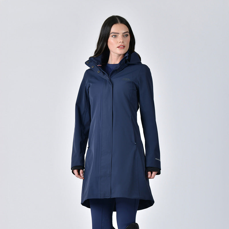Woman in Weatherbeeta Protect Waterproof Longline Riding Jacket Navy stands against a light background.
