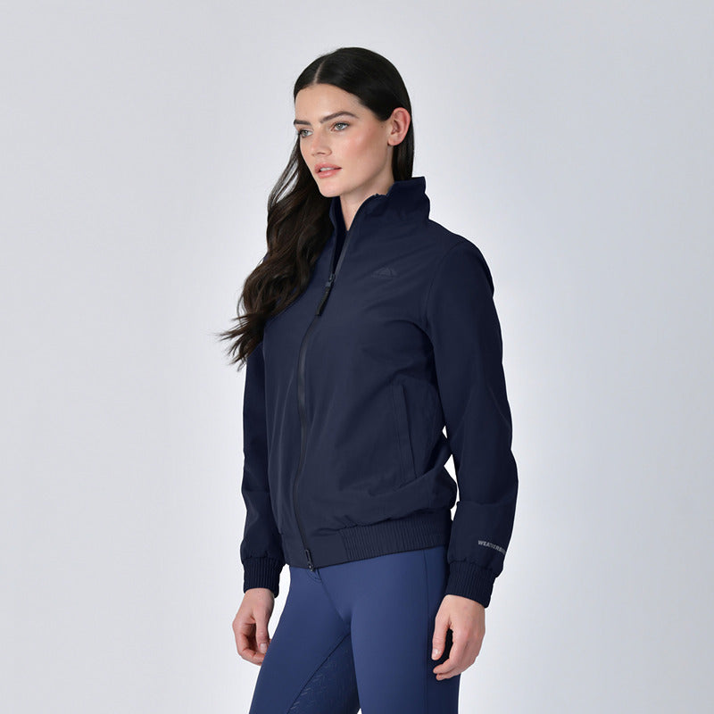 Woman in Weatherbeeta Waterproof Team Jacket Navy standing against a plain light background.