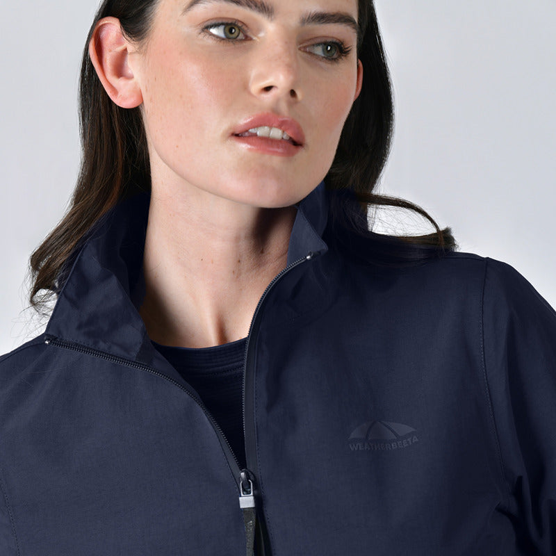 Woman in a Weatherbeeta Waterproof Team Jacket Navy, looking slightly to the side.