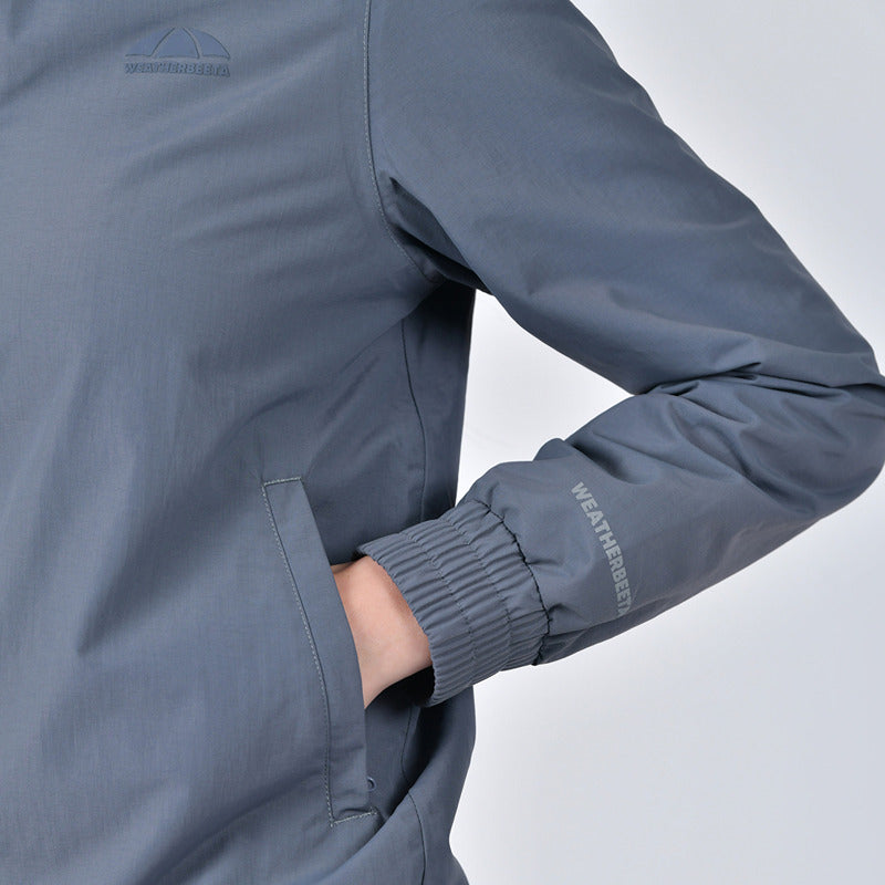 Wearing a Weatherbeeta Waterproof Team Jacket Slate Blue, hand in pocket, logo on chest and sleeve.