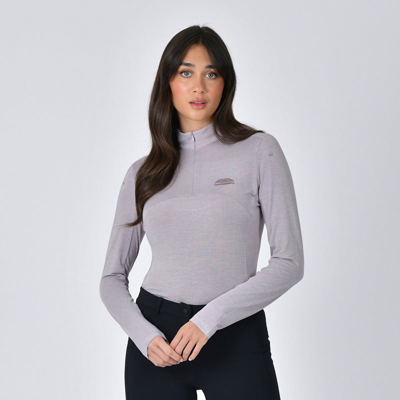 Woman wears Weatherbeeta 37.5 Lightweight Performance Top in Mauve Wine Marle and dark pants.