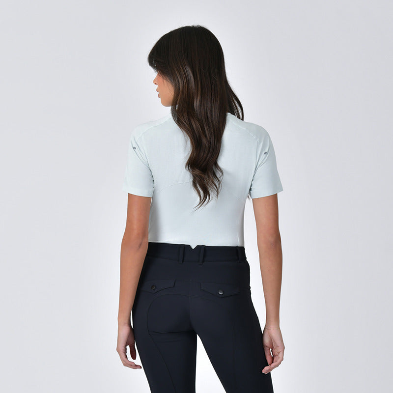 Woman with long dark hair wears a Weatherbeeta 37.5 Soft Sage Marle top and dark pants, back view.