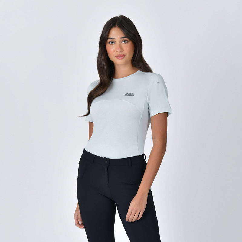 Woman with long dark hair wears a Weatherbeeta 37.5 Lightweight Short Sleeve Top in soft sage.