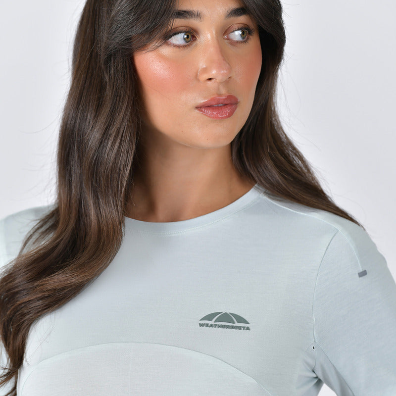 Woman with long brown hair in a Weatherbeeta 37.5 Lightweight Top in Soft Sage Marle, looking aside.